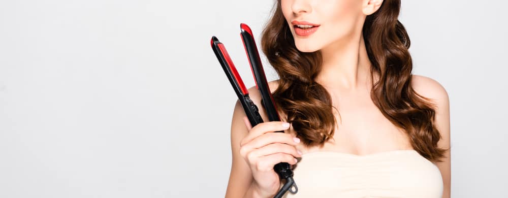 curly hair model holding flat iron in his hand